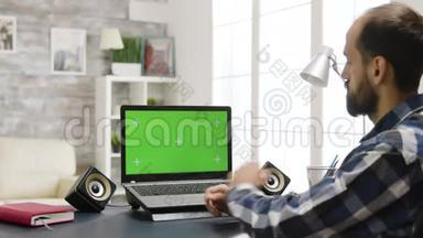 肩膀上<strong>放大镜</strong>头，男人看着绿色屏幕的笔记本<strong>电脑</strong>